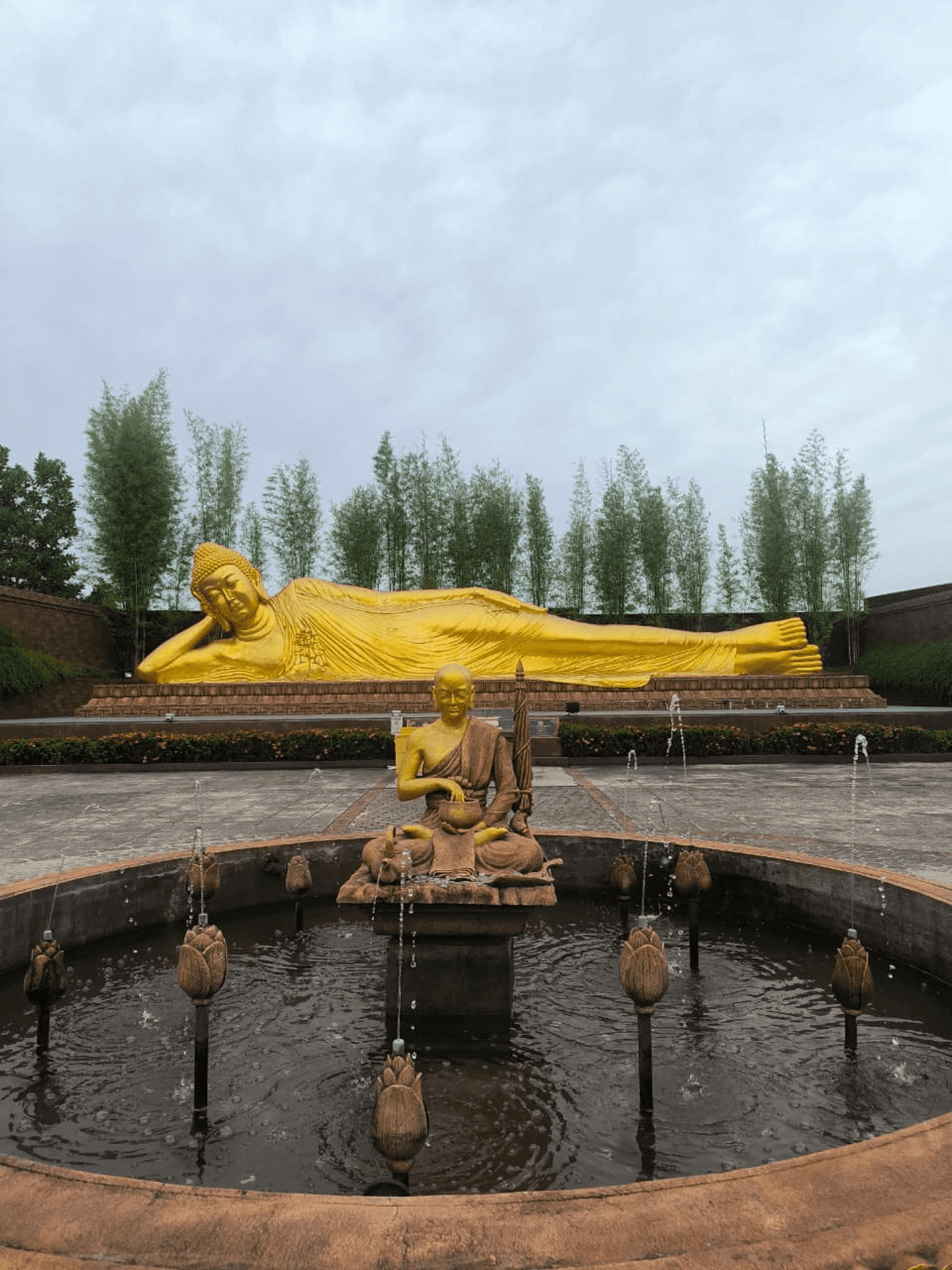Reclining Buddha statue with garden and pond